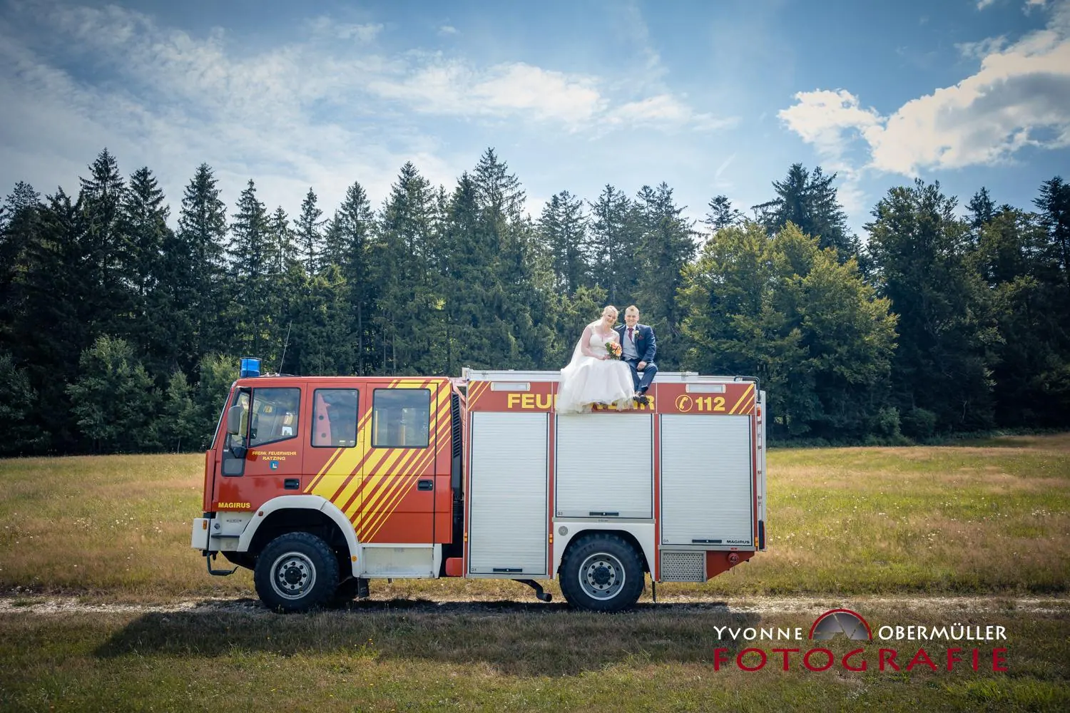 Brautpaar auf einem historischen Feuerwehrfahrzeug